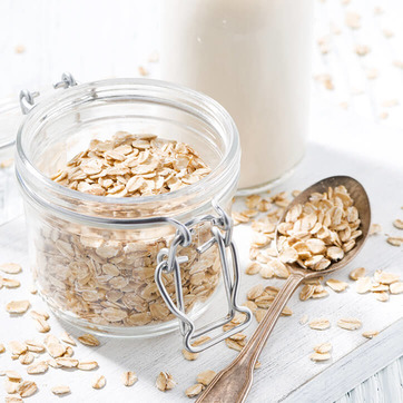 Haferflocken, die Zink enthalten, ein Löffel und ein Glas Milch